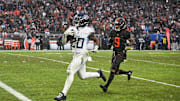 Dec 7, 2025; Cleveland, Ohio, USA; Tennessee Titans running back Tony Pollard (20) runs for a thirty-two yard touchdown against Cleveland Browns safety Grant Delpit (9) during the third quarter at Huntington Bank Field. Mandatory Credit: Ken Blaze-Imagn Images