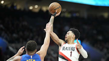 Feb 23, 2024; Portland, Oregon, USA; Portland Trail Blazers shooting guard Anfernee Simons (1) shoots the ball against Denver Nuggets small forward Michael Porter Jr. (1) during the first half at Moda Center. Mandatory Credit: Soobum Im-USA TODAY Sports