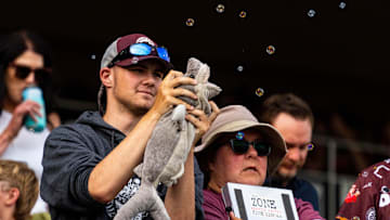 Jun 19, 2024; Omaha, NE, USA; A Texas A&M Aggies fan uses a shark plushie to bite bubbles during celebrations after scoring a run against the Florida Gators during the first inning at Charles Schwab Field Omaha. Mandatory Credit: Dylan Widger-USA TODAY Sports