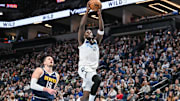 Jan 25, 2025; Minneapolis, Minnesota, USA; Minnesota Timberwolves guard Anthony Edwards (5) goes to the basket for a slam dunk over Denver Nuggets center Nikola Jokic (15) during the third quarter at Target Center. Mandatory Credit: Jeffrey Becker-Imagn Images