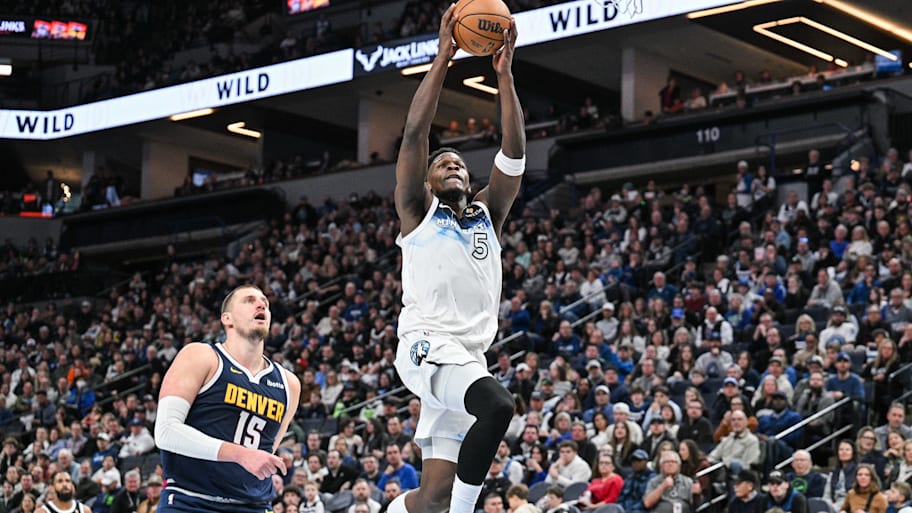 Minnesota Timberwolves guard Anthony Edwards goes to the basket for a slam dunk over Denver Nuggets center Nikola Jokić.