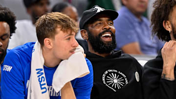 Oct 6, 2025; Fort Worth, Texas, USA; Dallas Mavericks forward Cooper Flagg (left) and guard Kyrie Irving (right) look on during the game between the Dallas Mavericks and the Oklahoma City Thunder at Dickie's Arena. Mandatory Credit: Jerome Miron-Imagn Images