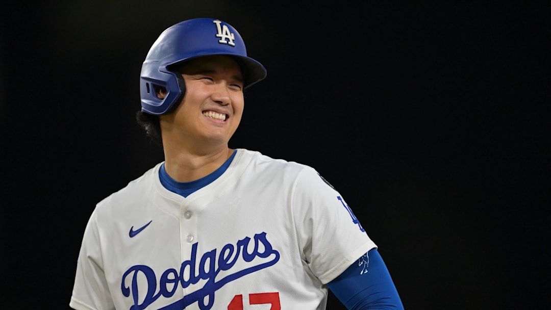Sep 10, 2025; Los Angeles, California, USA; Los Angeles Dodgers designated hitter Shohei Ohtani (17) smiles after he was awarded first base on catcher interference during the eighth inning against the Colorado Rockies at Dodger Stadium. Mandatory Credit: Jayne Kamin-Oncea-Imagn Images