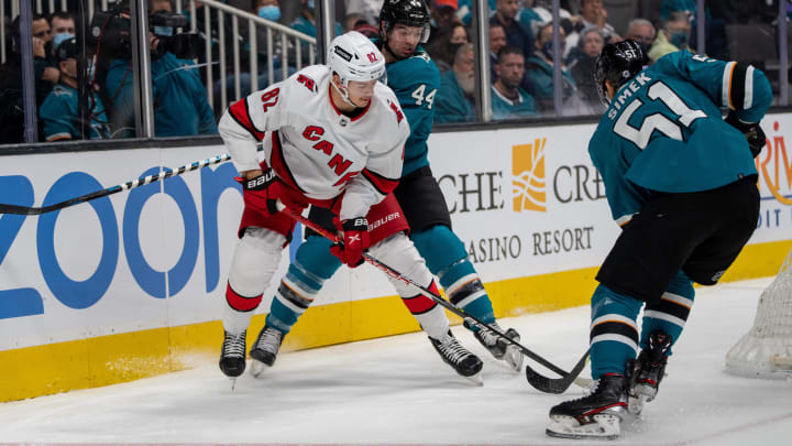 Nov 22, 2021; San Jose, California, USA;  San Jose Sharks defenseman Marc-Edouard Vlasic (44) and defenseman Radim Simek (51) battle for the puck against Carolina Hurricanes center Jesperi Kotkaniemi (82) behind the net during the first period at SAP Center at San Jose. Mandatory Credit: Neville E. Guard-USA TODAY Sports