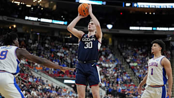 Mar 23, 2025; Raleigh, NC, USA; Connecticut Huskies forward Liam McNeeley (30) drives to the basket during the first half against Florida Gators center Rueben Chinyelu (9) in the second round of the NCAA Tournament at Lenovo Center. Mandatory Credit: Bob Donnan-Imagn Images