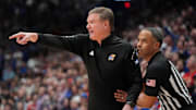 Jan 25, 2025; Lawrence, Kansas, USA; An official restrains Kansas Jayhawks head coach Bill Self against the Houston Cougars during overtime at Allen Fieldhouse. Mandatory Credit: Denny Medley-Imagn Images
