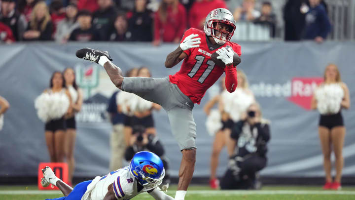 Dec 26, 2023; Phoenix, AZ, USA; UNLV Rebels wide receiver Ricky White (11) catches a touchdown pass against Kansas Jayhawks cornerback Cobee Bryant (2) during the second half at Chase Field. Mandatory Credit: Joe Camporeale-USA TODAY Sports