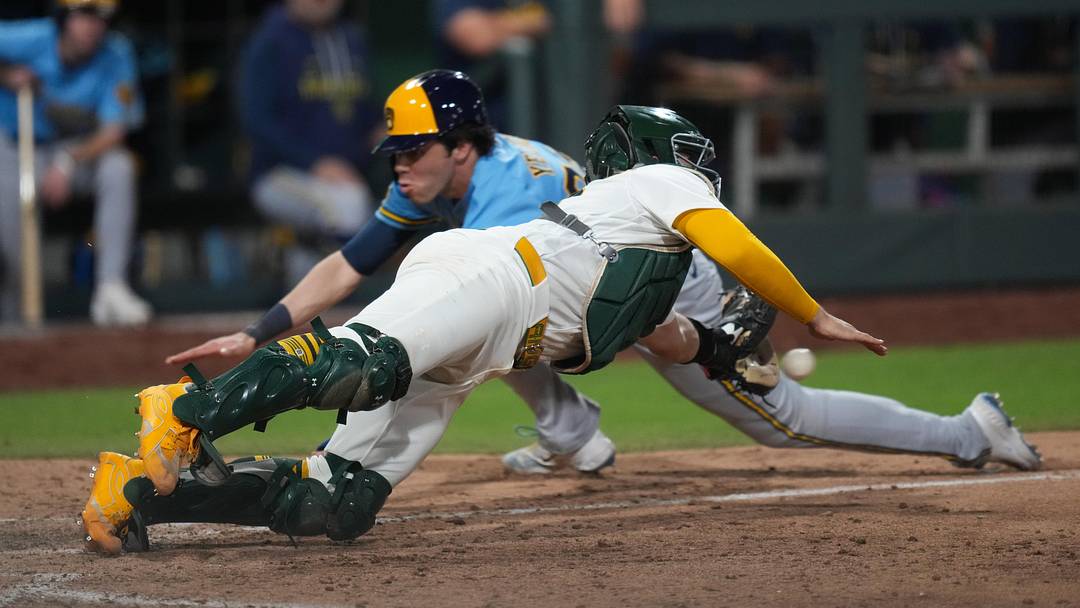 Jun 8, 2026; Summerlin, Nevada, USA; Milwaukee Brewers designated hitter Christian Yelich (22) slides past Athletics catcher Shea Langeliers (23) to home plate during the eleventh inning at the Las Vegas Ballpark. Mandatory Credit: Lucas Peltier-Imagn Images
