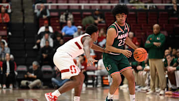 Jan 22, 2025; Stanford, California, USA; Miami (FL) Hurricanes guard Austin Swartz (23) dribbles against Stanford Cardinal guard Jaylen Blakes (21) in the first half at Maples Pavilion. Mandatory Credit: Eakin Howard-Imagn Images