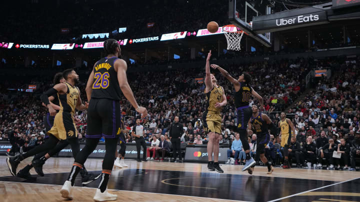 Apr 2, 2024; Toronto, Ontario, CAN;Toronto Raptors forward Kelly Olynyk (41) drives to the basket as Los Angeles Lakers guard Max Christie (10) tries to defend during the fourth quarter at Scotiabank Arena. Mandatory Credit: Nick Turchiaro-USA TODAY Sports.