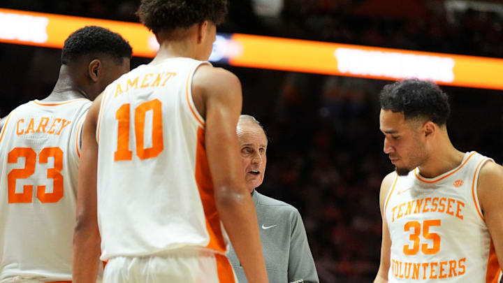 Tennessee basketball coach Rick Barnes huddles with Tennessee forwards Jaylen Carey (23) and Nate Ament (10), and guard Ethan Burg (35).