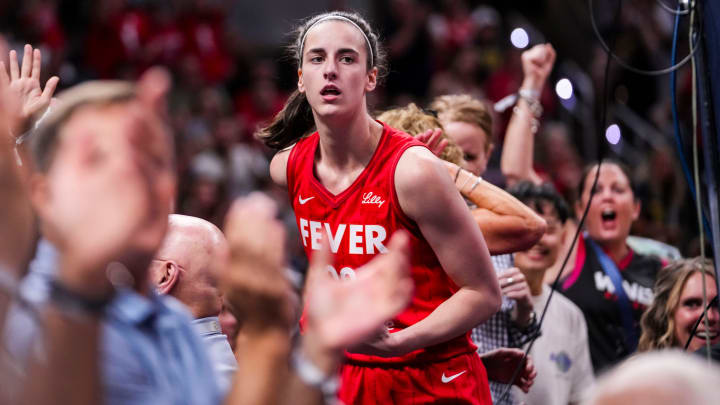 Indiana Fever guard Caitlin Clark celebrates with fans behind the basket during a game at Gainbridge Fieldhouse on Aug. 16.