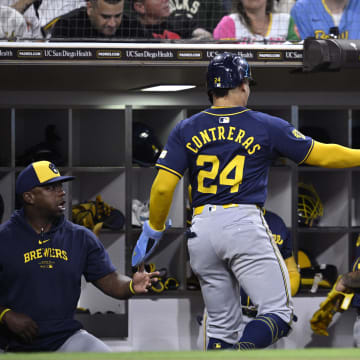 Jun 21, 2024; San Diego, California, USA; Milwaukee Brewers catcher William Contreras (24) is congratulated at the dugout after scoring a run against the San Diego Padres during the fifth inning at Petco Park.