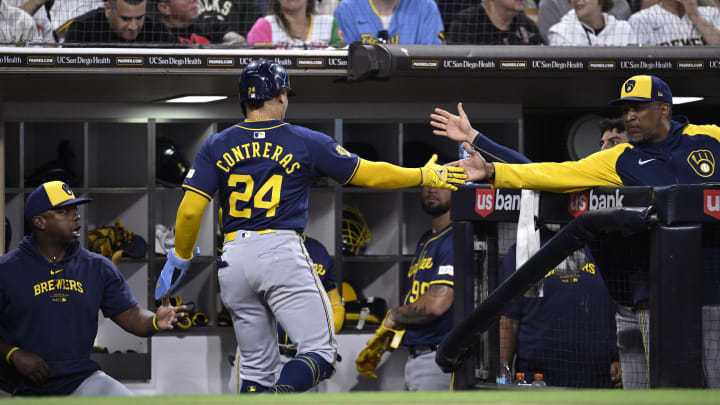 Jun 21, 2024; San Diego, California, USA; Milwaukee Brewers catcher William Contreras (24) is congratulated at the dugout after scoring a run against the San Diego Padres during the fifth inning at Petco Park.
