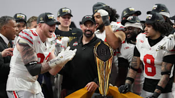 Jan 20, 2025; Atlanta, GA, USA; Ohio State Buckeyes defensive end Jack Sawyer (33) and Ohio State Buckeyes head coach Ryan Day celebrate on the podium after defeating the Notre Dame Fighting Irish in the CFP National Championship college football game at Mercedes-Benz Stadium. Mandatory Credit: Kirby Lee-Imagn Images