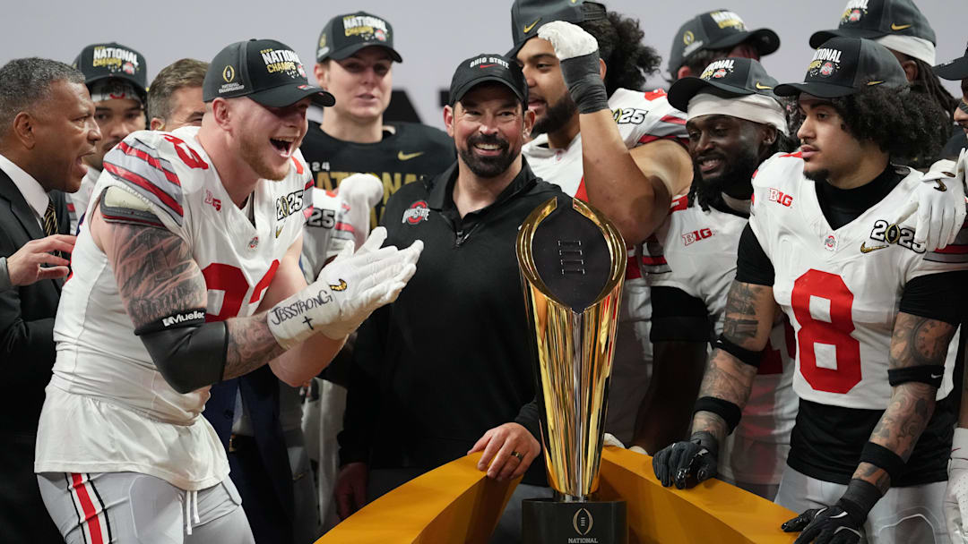 Jan 20, 2025; Atlanta, GA, USA; Ohio State Buckeyes defensive end Jack Sawyer (33) and Ohio State Buckeyes head coach Ryan Day celebrate on the podium after defeating the Notre Dame Fighting Irish in the CFP National Championship college football game at Mercedes-Benz Stadium. Mandatory Credit: Kirby Lee-Imagn Images