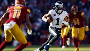 Dec 22, 2024; Landover, Maryland, USA; Philadelphia Eagles quarterback Jalen Hurts (1) against Washington Commanders safety Jeremy Chinn (11) during the first quarter at Northwest Stadium. Mandatory Credit: Peter Casey-Imagn Images