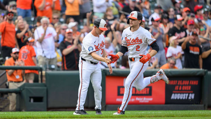 Aug 18, 2024; Baltimore, Maryland, USA; Baltimore Orioles shortstop Gunnar Henderson (2) celebrates with third base coach Tony Mansolino (36) after hitting a home run during the sixth inning against the Boston Red Sox at Oriole Park at Camden Yards. 