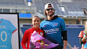 Mallory and Dansby Swanson pose during a ceremony honoring Mallory for her 100th cap.