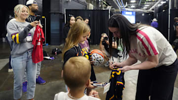 Fever guard Caitlin Clark signs autographs as ASU women's basketball head coach Molly Miller takes photos of her children Crosby and Cy at PHX Arena in Phoenix on Aug. 7, 2025.