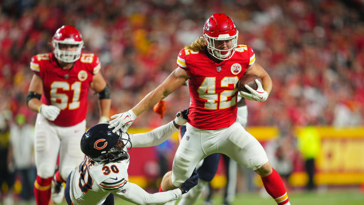 Aug 22, 2024; Kansas City, Missouri, USA; Kansas City Chiefs running back Carson Steele (42) runs the ball against Chicago Bears safety Tarvarius Moore (30) during the first half at GEHA Field at Arrowhead Stadium. Mandatory Credit: Jay Biggerstaff-USA TODAY Sports