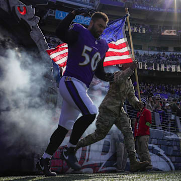 Nov 12, 2023; Baltimore, Maryland, USA;  Baltimore Ravens linebacker Kyle Van Noy (50) takes the field with a military service member before a game against the Cleveland Browns at M&T Bank Stadium. Mandatory Credit: Jessica Rapfogel-Imagn Images