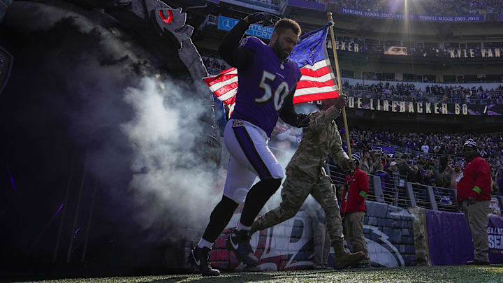 Nov 12, 2023; Baltimore, Maryland, USA; Baltimore Ravens linebacker Kyle Van Noy (50) takes the field with a military service member before a game against the Cleveland Browns at M&T Bank Stadium. Mandatory Credit: Jessica Rapfogel-Imagn Images
