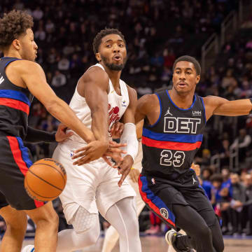 Dec 2, 2023; Detroit, Michigan, USA; Cleveland Cavaliers guard Donovan Mitchell (45) drives the ball up court between Detroit Pistons guard Cade Cunningham (2) and guard Jaden Ivey (23) during the first half at Little Caesars Arena. Mandatory Credit: David Reginek-USA TODAY Sports