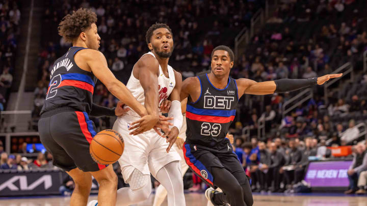 Dec 2, 2023; Detroit, Michigan, USA; Cleveland Cavaliers guard Donovan Mitchell (45) drives the ball up court between Detroit Pistons guard Cade Cunningham (2) and guard Jaden Ivey (23) during the first half at Little Caesars Arena. Mandatory Credit: David Reginek-USA TODAY Sports