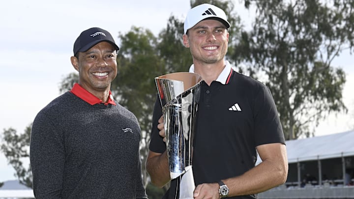 Ludvig Åberg accepted the Genesis Invitational trophy from Tiger Woods.