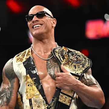 Dwayne The Rock Johnson proudly carrying the People's Championship Belt on his shoulder. Topps announced that The Rock would have autographed cards  in Chrome WWE coming out later this year. 