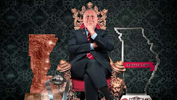 Arkansas coach Sam Pittman sits on a throne surrounded by trophies collected by his team throughout the 2021 season.