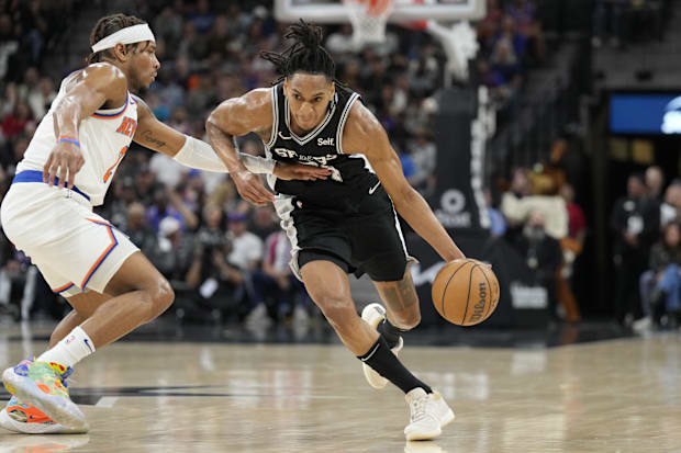 San Antonio Spurs guard Devin Vassell (24) drives to the basket while defended by New York Knicks guard Miles McBride (2).