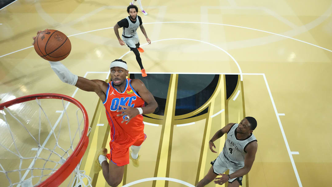 Dec 13, 2025; Las Vegas, Nevada, USA;  Oklahoma City Thunder guard Shai Gilgeous-Alexander (2) goes up for the lay up as San Antonio Spurs guard De'Aaron Fox (4) looks on during the second half at T-Mobile Arena. Mandatory Credit: Kirby Lee-Imagn Images