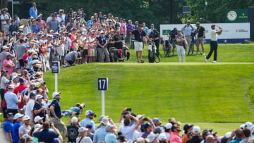 Tiger Woods drives off on the 17th tee as a large crowd of spectators watch during the 2024 PGA