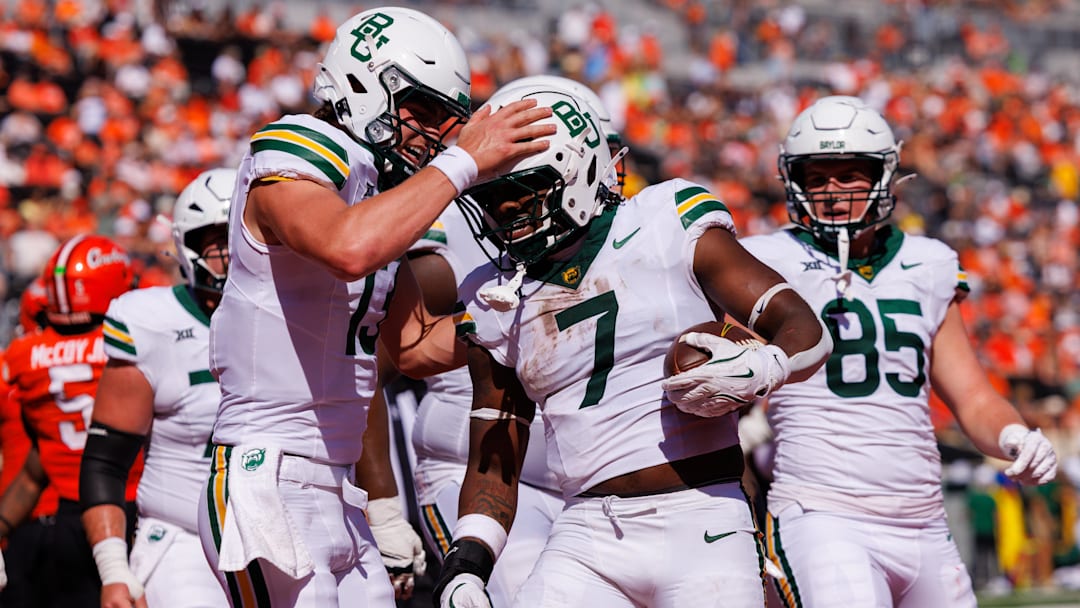 Sep 27, 2025; Stillwater, Oklahoma, USA; Baylor Bears quarterback Sawyer Robertson (13) celebrates with Baylor Bears running back Bryson Washington (7) after a touchdown during the first half against the Oklahoma State Cowboys at Boone Pickens Stadium. Mandatory Credit: William Purnell-Imagn Images