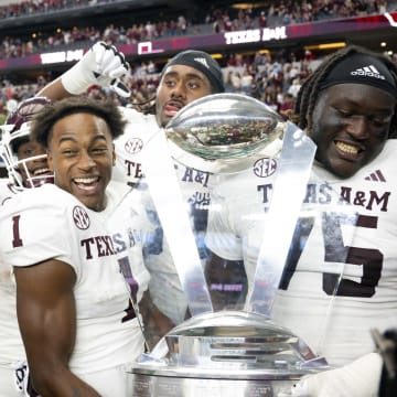 Sep 30, 2023; Arlington, Texas, USA; DUPLICATE***Texas A&M Aggies wide receiver Evan Stewart (1) and offensive lineman Kam Dewberry (75) celebrate with the Southwest Classic trophy after the Aggies victory over the Arkansas Razorbacks at AT&T Stadium. Mandatory Credit: Jerome Miron-USA TODAY Sports