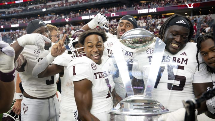 Sep 30, 2023; Arlington, Texas, USA; DUPLICATE***Texas A&M Aggies wide receiver Evan Stewart (1) and offensive lineman Kam Dewberry (75) celebrate with the Southwest Classic trophy after the Aggies victory over the Arkansas Razorbacks at AT&T Stadium. Mandatory Credit: Jerome Miron-USA TODAY Sports