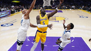 Oct 24, 2025; Los Angeles, California, USA; Los Angeles Lakers center Deandre Ayton (5) shoots the ball against Minnesota Timberwolves center Rudy Gobert (27) and forward Jaden McDaniels (3) in the second half at Crypto.com Arena. Mandatory Credit: Kirby Lee-Imagn Images