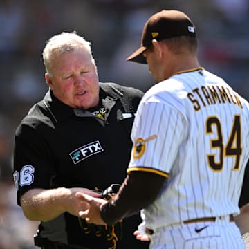 Apr 16, 2022; San Diego, California, USA; San Diego Padres relief pitcher Craig Stammen (34) is checked by umpire Bill Miller (26) during the middle of the sixth inning against the Atlanta Braves at Petco Park. Mandatory Credit: Orlando Ramirez-Imagn Images