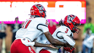 Sep 11, 2025; Winston-Salem, North Carolina, USA;  North Carolina State Wolfpack quarterback CJ Bailey (11) hands off to Hollywood Smothers (3) in the first half against the Wake Forest Demon Deacons at Allegacy Federal Credit Union Stadium. Mandatory Credit: Luke Jamroz-Imagn Images