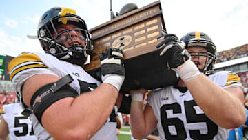 Sep 9, 2023; Ames, Iowa, USA; Iowa Hawkeyes offensive lineman Nick DeJong (56) and offensive lineman Logan Jones (65) carry the Cy-Hawk trophy after the game against the Iowa State Cyclones at Jack Trice Stadium. Mandatory Credit: Jeffrey Becker-Imagn Images
