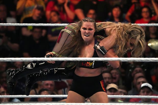 Ronda Rousey (vestimenta negra) y Natalya (vestimenta verde) luchan durante el partido del Campeonato Femenino de Smackdown.