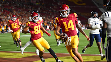 Sep 7, 2024; Los Angeles, California, USA; USC Trojans quarterback Jayden Maiava (14) scores a touchdown against the Utah State Aggies during the fourth quarter at United Airlines Field at Los Angeles Memorial Coliseum. Mandatory Credit: Jonathan Hui-Imagn Images