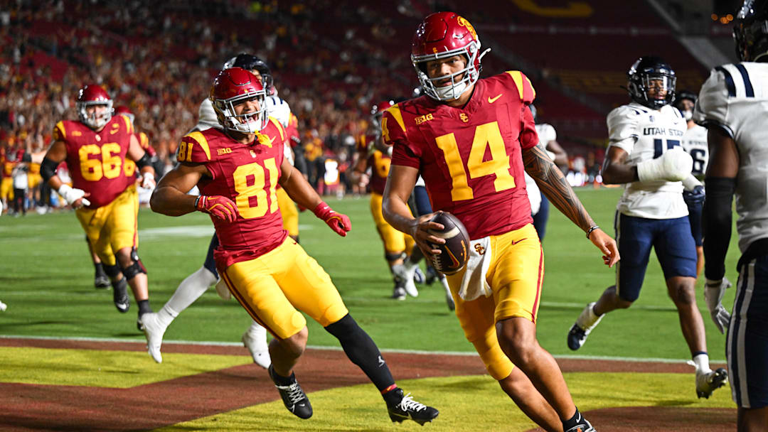 Sep 7, 2024; Los Angeles, California, USA; USC Trojans quarterback Jayden Maiava (14) scores a touchdown against the Utah State Aggies during the fourth quarter at United Airlines Field at Los Angeles Memorial Coliseum. Mandatory Credit: Jonathan Hui-Imagn Images