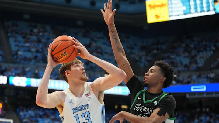 Dec 13, 2025; Chapel Hill, North Carolina, USA; North Carolina Tar Heels center Henri Veesaar (13) with the ball as USC Upstate Spartans forward Jafeth Martinez (12) defends in the second half at Dean E. Smith Center. Mandatory Credit: Bob Donnan-Imagn Images