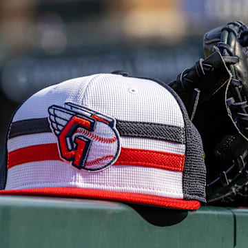 Jul 8, 2024; Detroit, Michigan, USA; A Cleveland Guardians baseball cap and glove sit on the dugout rail before the game against the Detroit Tigers at Comerica Park. Mandatory Credit: David Reginek-Imagn Images