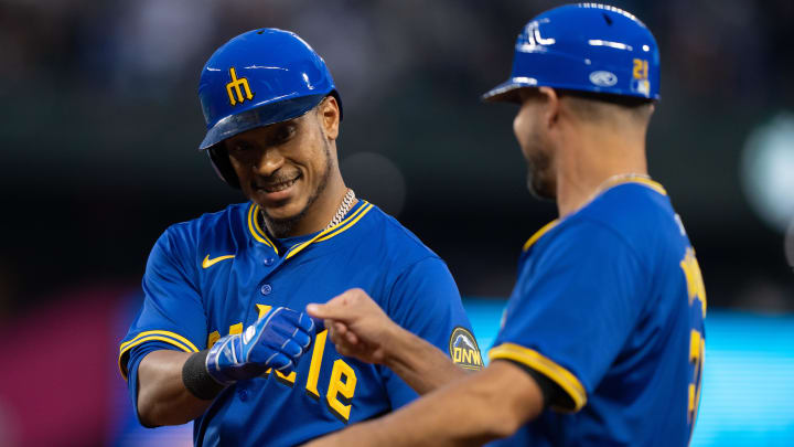 Seattle Mariners second baseman Jorge Polanco (7), left, is congratulated by first base coach Kristopher Negron after a bunt for a base hit during the ninth inning against the Minnesota Twins at T-Mobile Park on June 28.