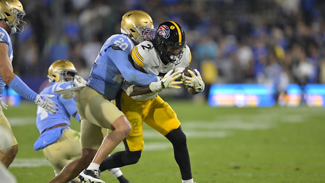 Nov 8, 2024; Pasadena, California, USA;  UCLA Bruins linebacker Kain Medrano (20) stops Iowa Hawkeyes running back Kaleb Johnson (2) for a loss in the second half at the Rose Bowl. 