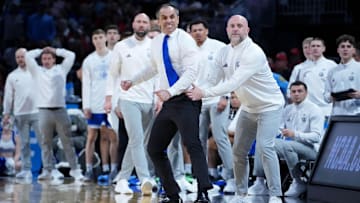 Mar 22, 2025; Wichita, KS, USA; Drake Bulldogs head coach Ben McCollum is held back by staff as he reacts to a call following a play against the Texas Tech Red Raiders during the second half at Intrust Bank Arena. Mandatory Credit: Kirby Lee-Imagn Images